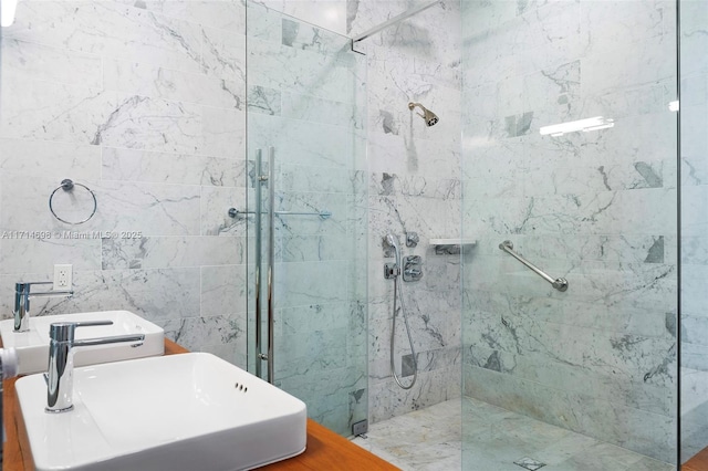 bathroom featuring sink, a shower with door, and tile walls