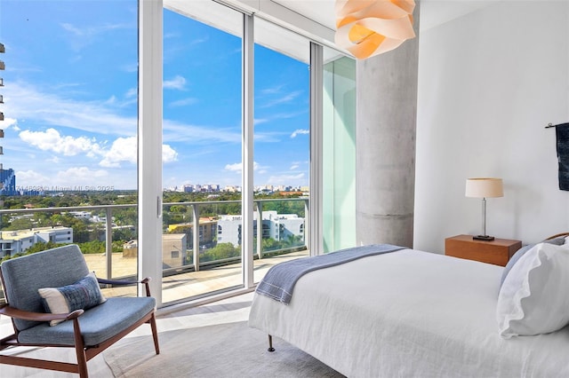 bedroom with access to outside and a wall of windows