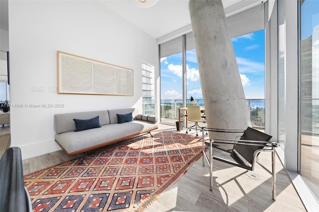 living room featuring light wood-type flooring and a wall of windows