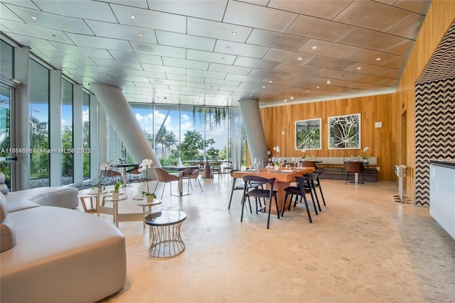 dining area with expansive windows and wooden walls