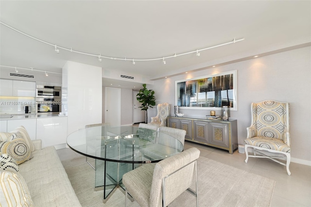 dining space featuring light tile patterned flooring and track lighting