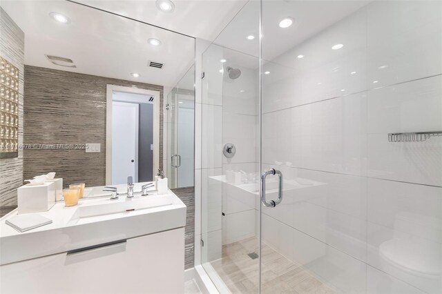 bathroom featuring vanity, toilet, and an enclosed shower