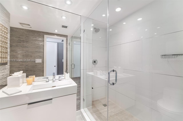 full bathroom with tile walls, recessed lighting, visible vents, vanity, and a shower stall