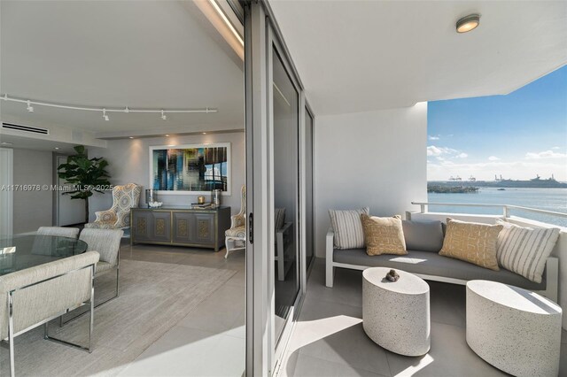 balcony featuring an outdoor living space and a water view