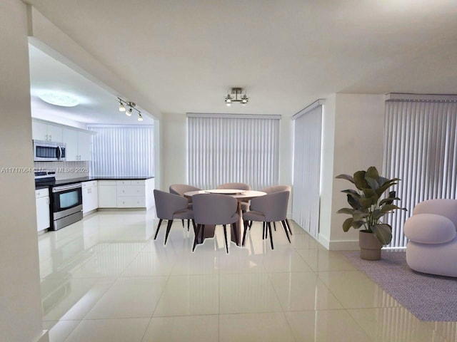 dining room with light tile patterned floors and track lighting