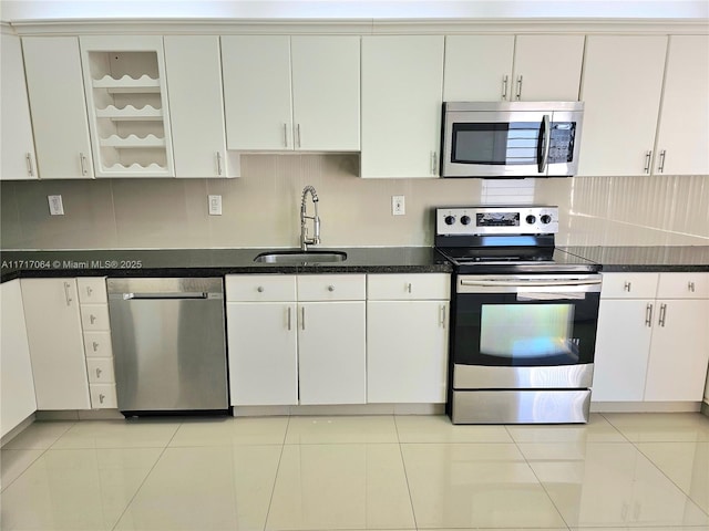 kitchen featuring a sink, tasteful backsplash, appliances with stainless steel finishes, and white cabinets