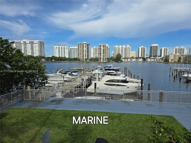 view of dock with a city view, a yard, and a water view