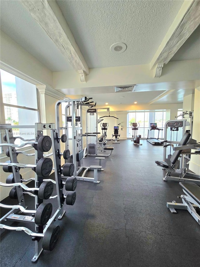 exercise room with visible vents and a textured ceiling