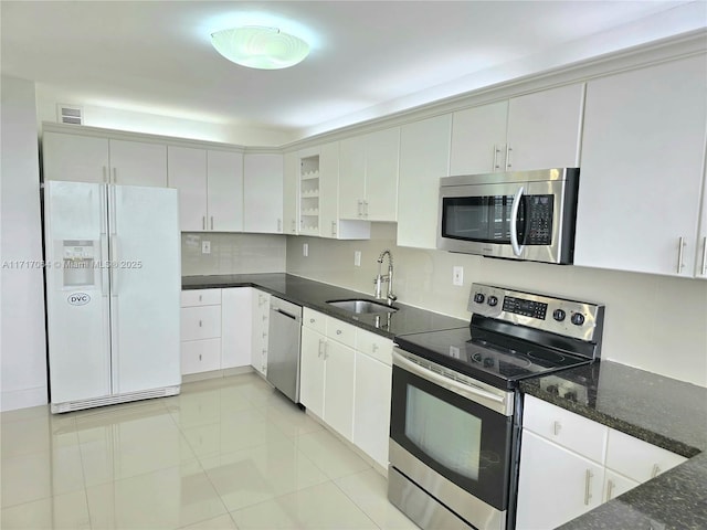 18051 Biscayne Blvd Unit 1204, Aventura, FL 33160 - kitchen with stainless steel appliances, a sink, dark stone countertops, backsplash, and white cabinets