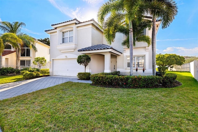 mediterranean / spanish-style home featuring a garage, stucco siding, a tile roof, decorative driveway, and a front yard