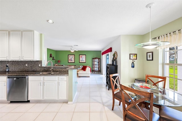 kitchen featuring dishwasher, sink, kitchen peninsula, decorative light fixtures, and white cabinets