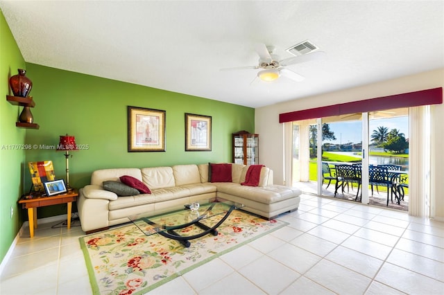 tiled living room featuring a water view and ceiling fan