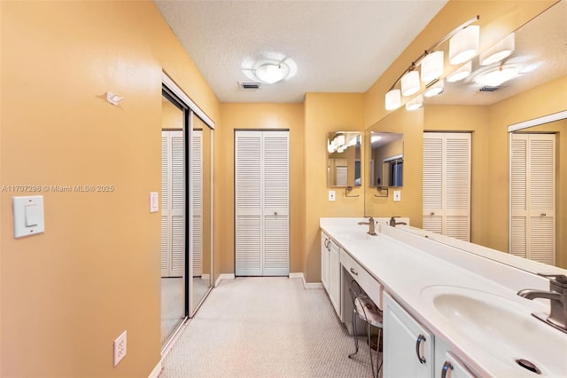 bathroom with a textured ceiling and vanity