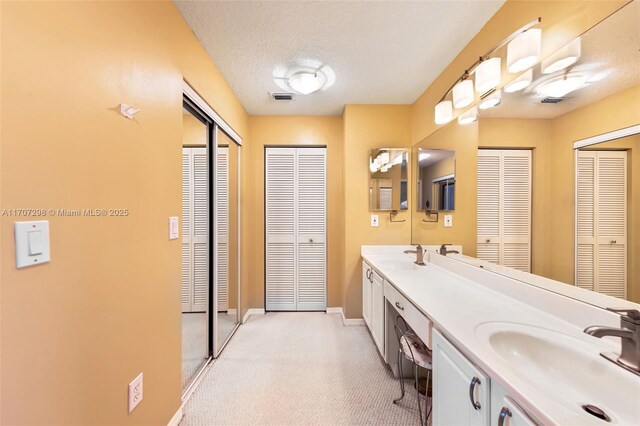 2355 NW 137th Ter, Sunrise, FL 33323 - bathroom featuring a closet, double vanity, and baseboards