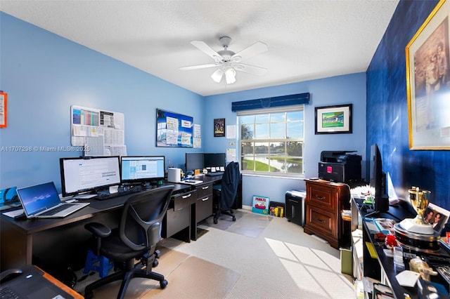 office area featuring ceiling fan, light colored carpet, and a textured ceiling