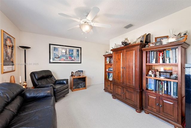 carpeted living room with ceiling fan