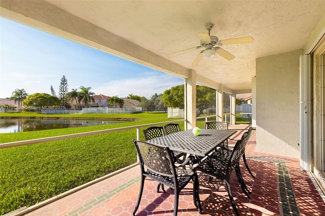 view of patio with a water view and ceiling fan