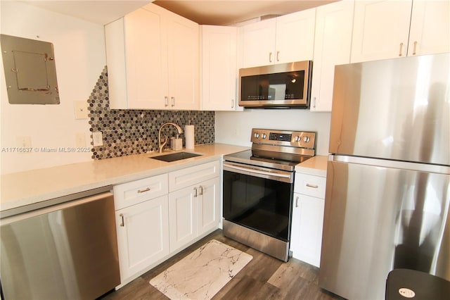 kitchen with backsplash, electric panel, white cabinets, sink, and stainless steel appliances