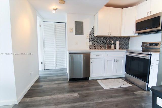 kitchen with tasteful backsplash, stainless steel appliances, sink, white cabinets, and electric panel