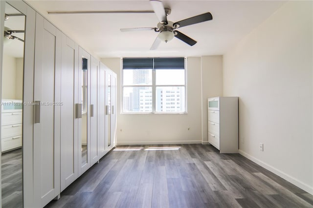 unfurnished bedroom featuring ceiling fan and dark hardwood / wood-style floors