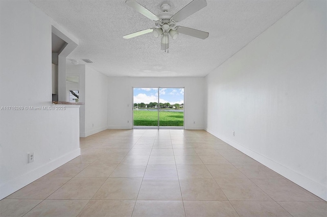 spare room with ceiling fan and light tile patterned floors