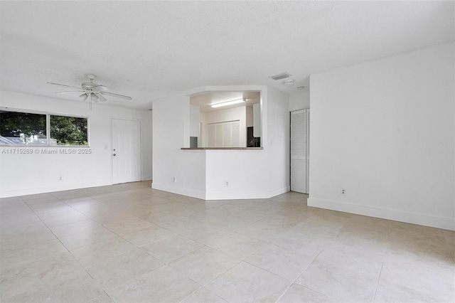 unfurnished living room featuring a textured ceiling, ceiling fan, and light tile patterned flooring