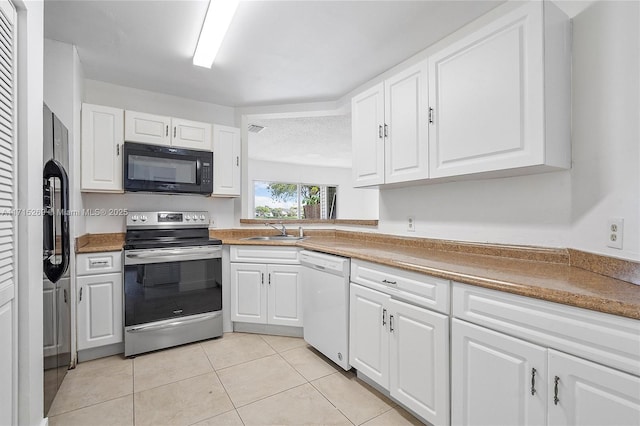 kitchen featuring appliances with stainless steel finishes, a textured ceiling, sink, light tile patterned floors, and white cabinets