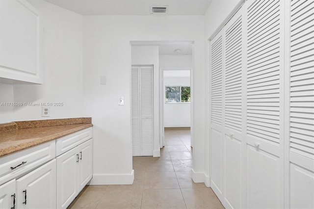 interior space featuring white cabinets and light tile patterned floors