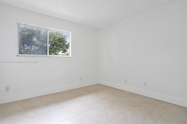 tiled empty room with a textured ceiling