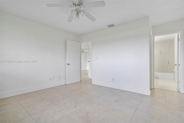 unfurnished room with a textured ceiling, ceiling fan, and light tile patterned flooring