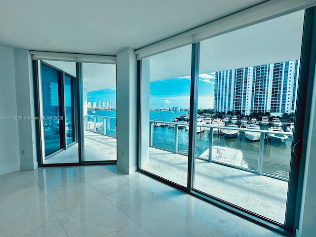 unfurnished room with floor to ceiling windows and a water view