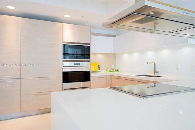 kitchen featuring range hood, modern cabinets, a sink, and oven