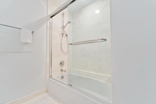 full bath featuring shower / bath combination with glass door and baseboards