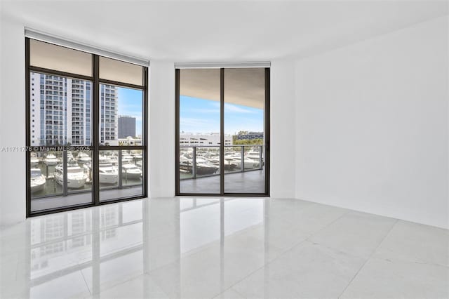 17301 Biscayne Blvd Unit 305, North Miami Beach, FL 33160 - tiled spare room featuring a city view and a wall of windows