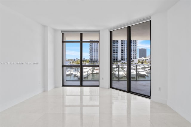 17301 Biscayne Blvd Unit 305, North Miami Beach, FL 33160 - spare room with floor to ceiling windows, a view of city, healthy amount of natural light, a water view, and tile patterned floors