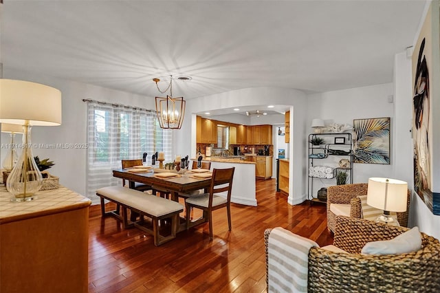 dining space featuring an inviting chandelier and dark wood-type flooring