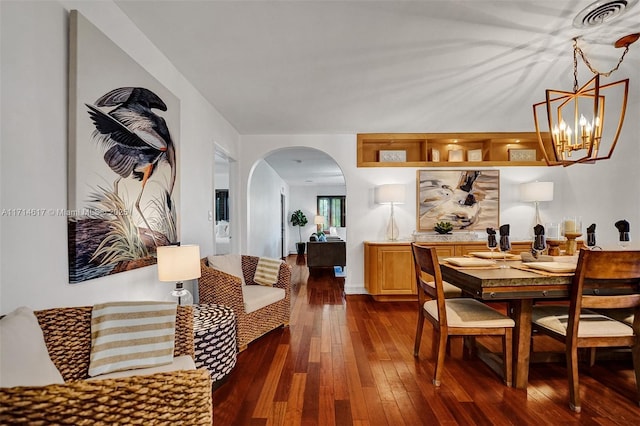 dining area featuring dark wood-type flooring and a notable chandelier