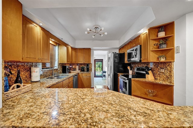 kitchen with a notable chandelier, sink, appliances with stainless steel finishes, and tasteful backsplash