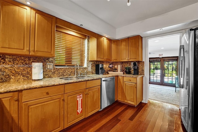 kitchen featuring sink, french doors, light stone counters, dark hardwood / wood-style flooring, and appliances with stainless steel finishes