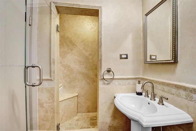 bathroom with tile walls, sink, and walk in shower