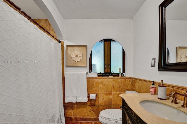 bathroom with vanity, toilet, tile walls, and french doors