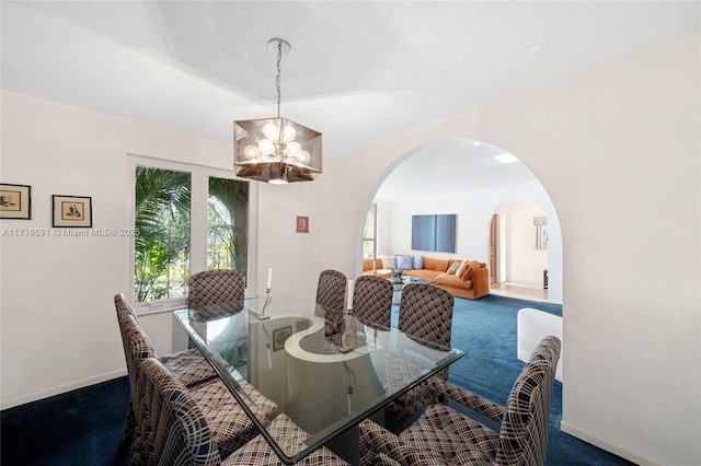 dining room featuring carpet flooring and a chandelier