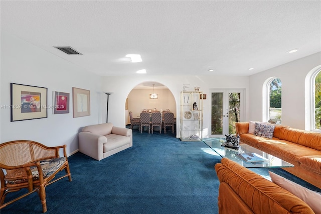 living room featuring french doors, carpet, and a textured ceiling