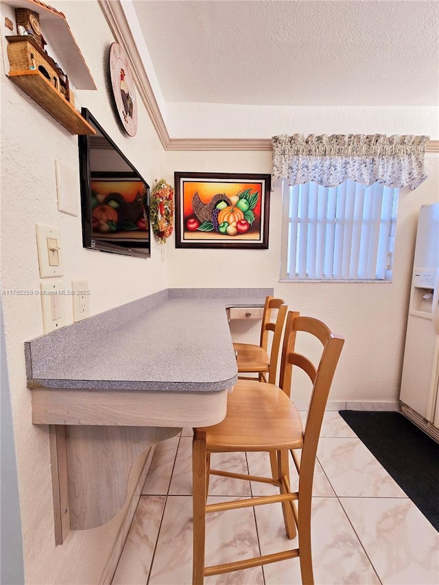 tiled dining space featuring a textured ceiling