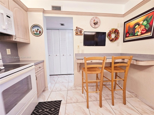 kitchen with backsplash, white appliances, and light brown cabinetry