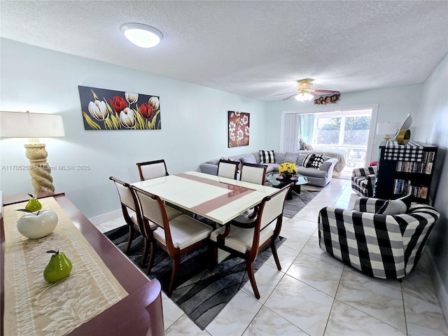 dining space featuring ceiling fan and a textured ceiling