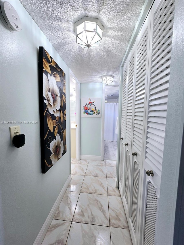 hallway with a textured ceiling