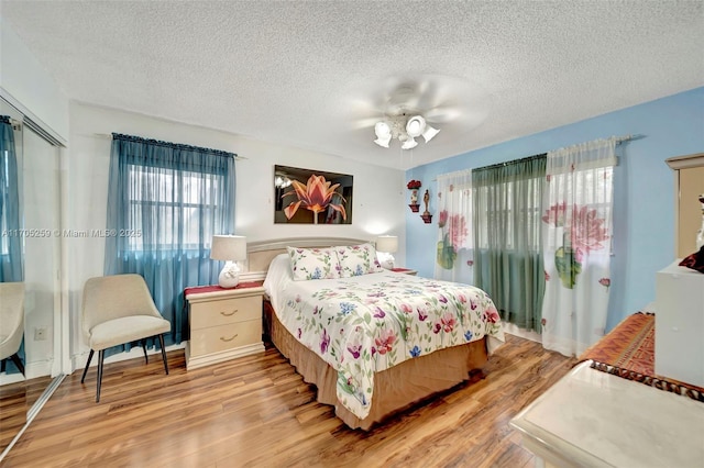 bedroom featuring a textured ceiling, light hardwood / wood-style flooring, and ceiling fan