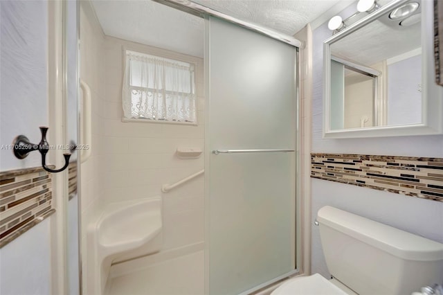 bathroom featuring toilet, walk in shower, and a textured ceiling