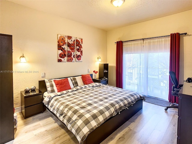 bedroom with light hardwood / wood-style flooring and a textured ceiling